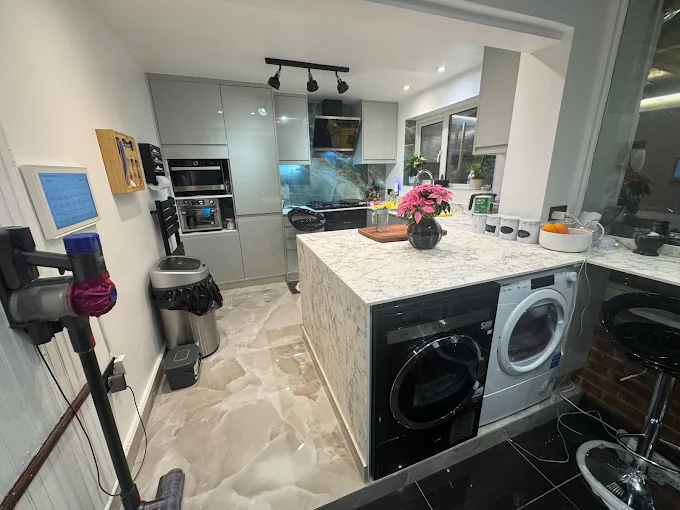 Grey gloss kitchen with marble waterfall island and integrated appliances